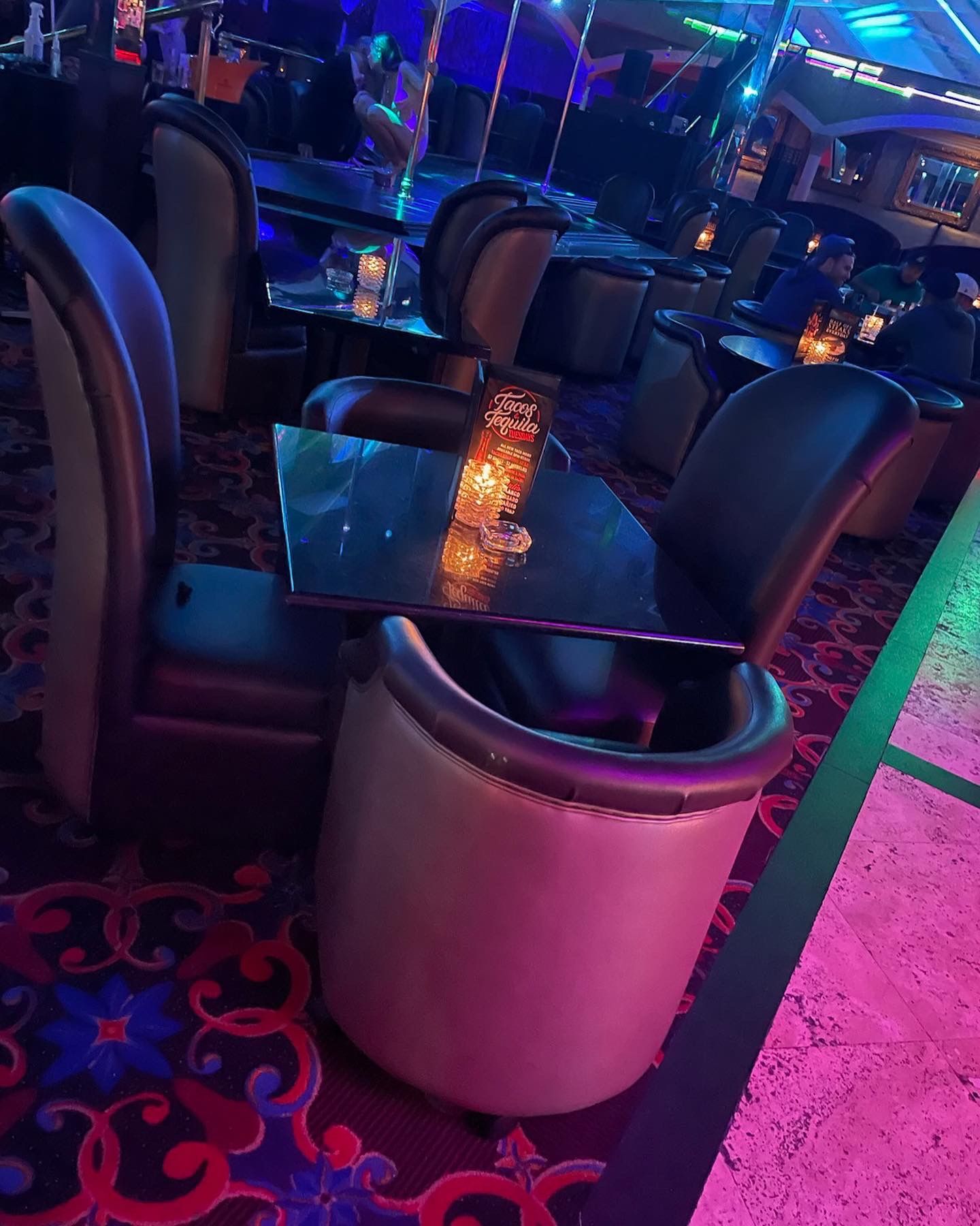 tables with dining parlor chairs around them in a nightclub